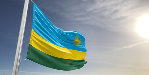 Rwanda national flag cloth fabric waving on beautiful sky grey Background.