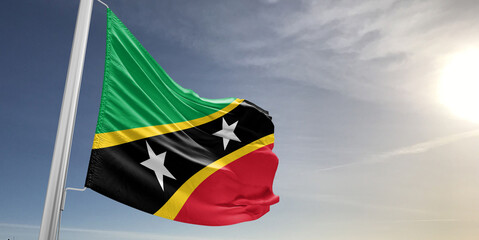 Saint Kitts and Nevis national flag cloth fabric waving on beautiful sky grey Background.
