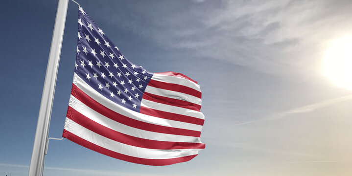 United States national flag cloth fabric waving on beautiful sky grey Background.