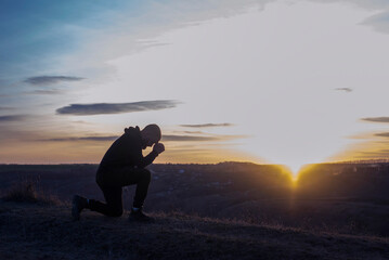 A man on his knees. Prayer of repentance for sins. Worship of God. - obrazy, fototapety, plakaty