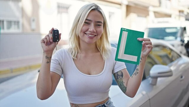 Young beautiful hispanic woman holding new drive license and keys standing by car at street