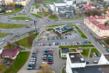 Obraz na płótnie Canvas Aerial view of a large parking lot full of cars. Drone flying over the city and car parking. Large Parking lot near the shopping center.