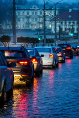 Traffic jam in the city at night during the rain. Rear view of cars standing on the road and red...