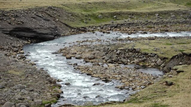 Fantastic landscape with flowing rivers and streams with rocks and grass in Iceland.