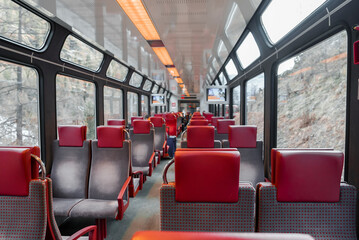 Naklejka premium Interior of empty cabin of modern passenger train with seats arranged in a row by windows, luxury travel concept