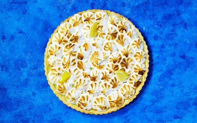 Traditional french lemon Meringue tart on blue grunge background
