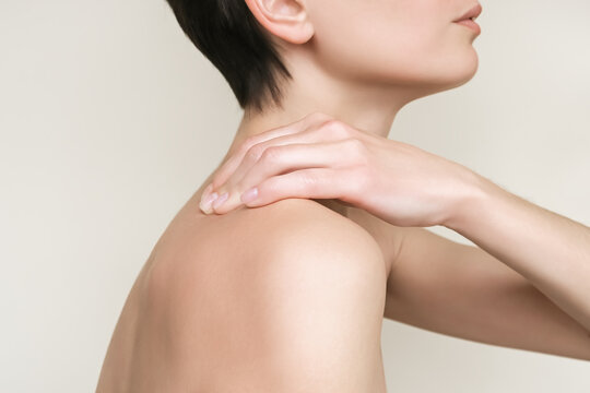 a woman feels pain in her neck and back and massages her deltoid muscle and shoulders
