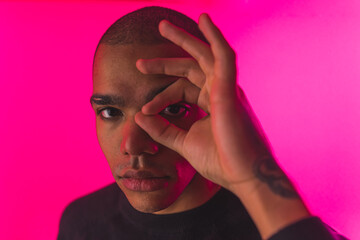 Close portrait of African American man with finger circle over his eye . High quality photo
