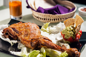 Cabrito leg with guacamole and tortillas