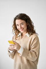 Smiling pretty curly young woman model using mobile phone, happy girl holding smartphone browsing internet on cellphone technology device standing isolated on white background, vertical.