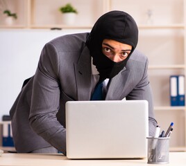 Male gangster stealing information from the office