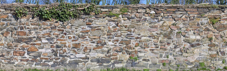 Rustic rough natural stone wall in panorama format. Can be seamlessly combined with second version to create a larger panorama.