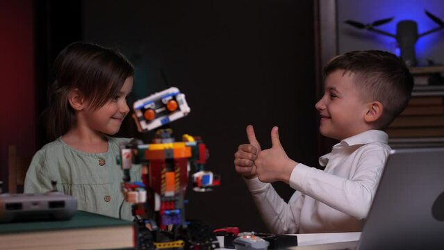 a boy and a little girl rejoice at the successful completion of the robot 