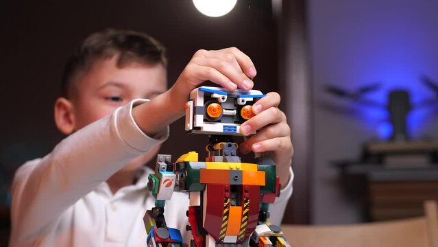 the boy attaches the antenna to the robot