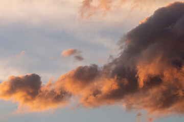 Blue sky with clouds with strange shape. Sunset time in Greece. Orange, white and gray colors