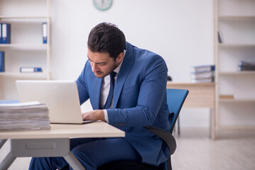 Young male employee and too much work in the office