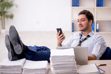 Young male employee and too much work in the office