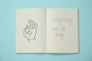 Notebook with phrase Everything Will Be Okay and drawing of hand showing gesture on light turquoise, top view