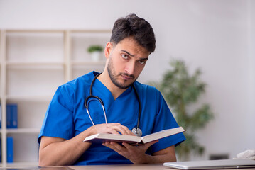 Young male doctor student reading the book