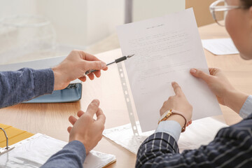 Businesspeople working with documents at wooden table in office, closeup