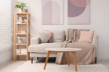 Stylish living room interior with sofa, coffee table and wooden shelf