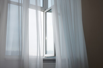 Fototapeta na wymiar Open window and elegant white curtains indoors. Interior design