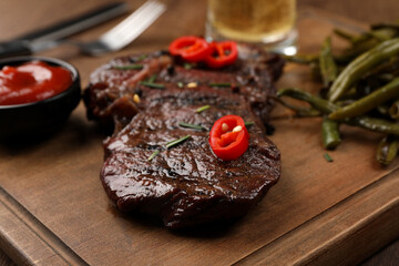 Delicious fried steak and sauce on wooden table, closeup