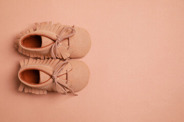 Naklejka premium Cute baby shoes on brown background, flat lay. Space for text