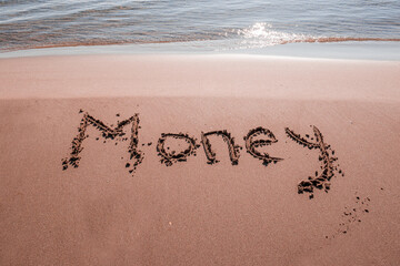 text MONEY on the sand of the sea