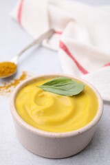 Tasty curry sauce, powder and basil leaf on light table