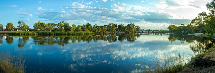 Panoramic view of Wimmera River. Riverbank with water reflection of beautiful cloudy sky,...