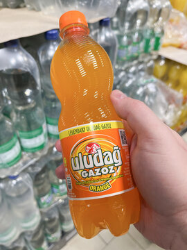 GERMANY - APR 15, 2023: A man&rsquo;s hand holding a chilled bottle of original Uludag Gazoz Orange