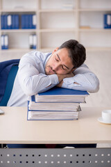 Young male employee sitting at workplace