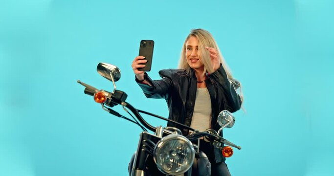 Selfie, blue background and woman on motorcycle with smile for adventure, road trip and holiday mockup. Motorbike, transport and happy girl take picture for social media, post or memory in studio