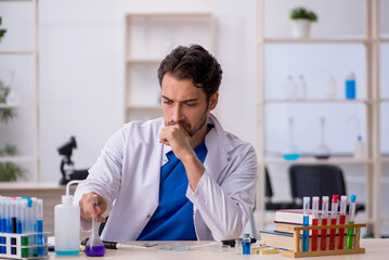 Young male chemist working at the lab