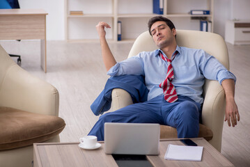 Young male employee sitting in the office