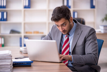 Fototapeta premium Young male employee working in the office