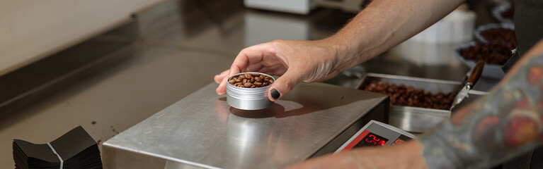 Male worker weighing coffee beans on scales