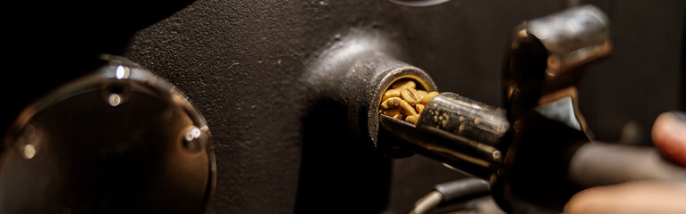 Male worker using industrial coffee roasting machine