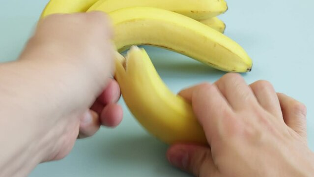 personne &eacute;pluchant une banane, en gros plan