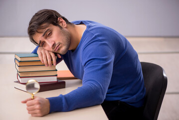 Fototapeta premium Young male student preparing for exams in the classroom