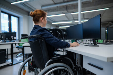 Fototapeta na wymiar Caucasian woman in wheelchair at work desk.