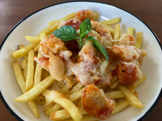 Mozarella Chicken Barbeque served with French Fries on white bowl isolated by wooden table
