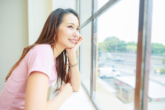 窓の外を覗く美人な日本人女性、オープンカフェ、笑顔