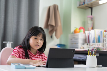 asian child back to school and smile study online class on computer tablet or kid girl student video call studying or person happy learn from home by fun learning on pad in classroom at homeschool