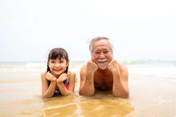 Happy Asian family travel ocean on summer holiday vacation. Grandfather and grandchildren girl in...