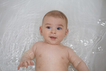 Portrait of a baby boy with blue eyes in the bath.