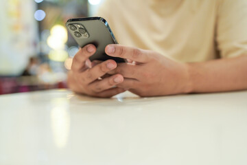 Relaxed young asian man using smart phone  spending time checking news social media.