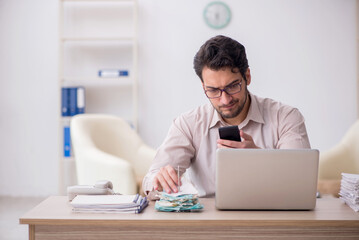 Young male accountant working in the office