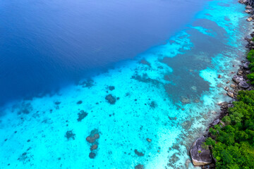 aerial view of beach and sea water surrounded by mountains In the beautiful summer of the Andaman Sea Amazing views, sandy beaches, turquoise waters and amazing corals under the sea.